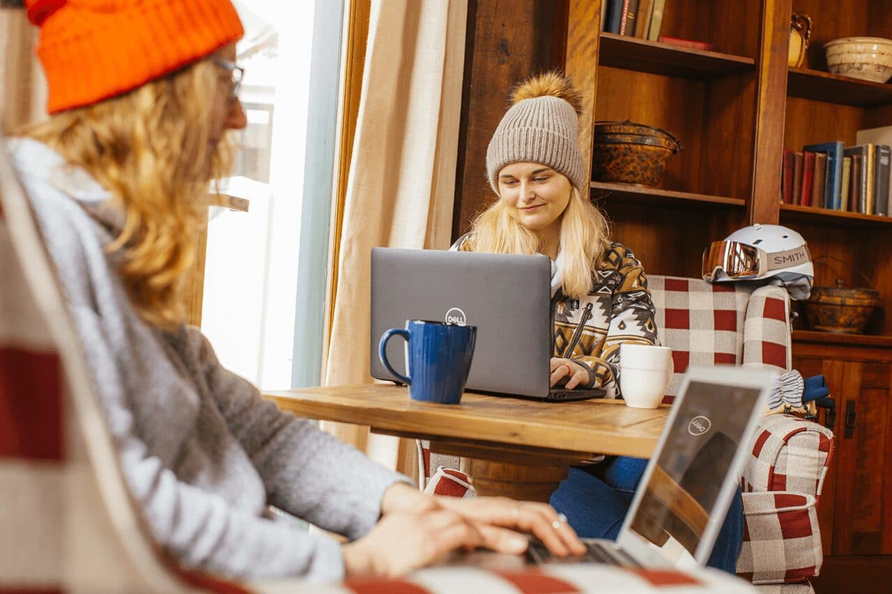 Remote worker on a laptop in a busy ski resort lodge common area